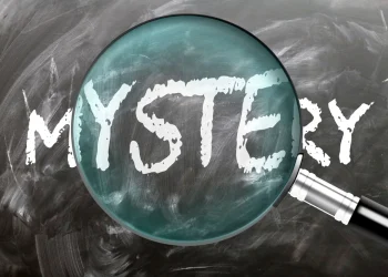 Filmes de mistério de Agatha Christie /Mistério - aprenda, estude e inspecione. Dando uma olhada mais de perto no mistério. Uma lupa ampliando a palavra "mistério" escrita em um quadro negro - imagem de stock